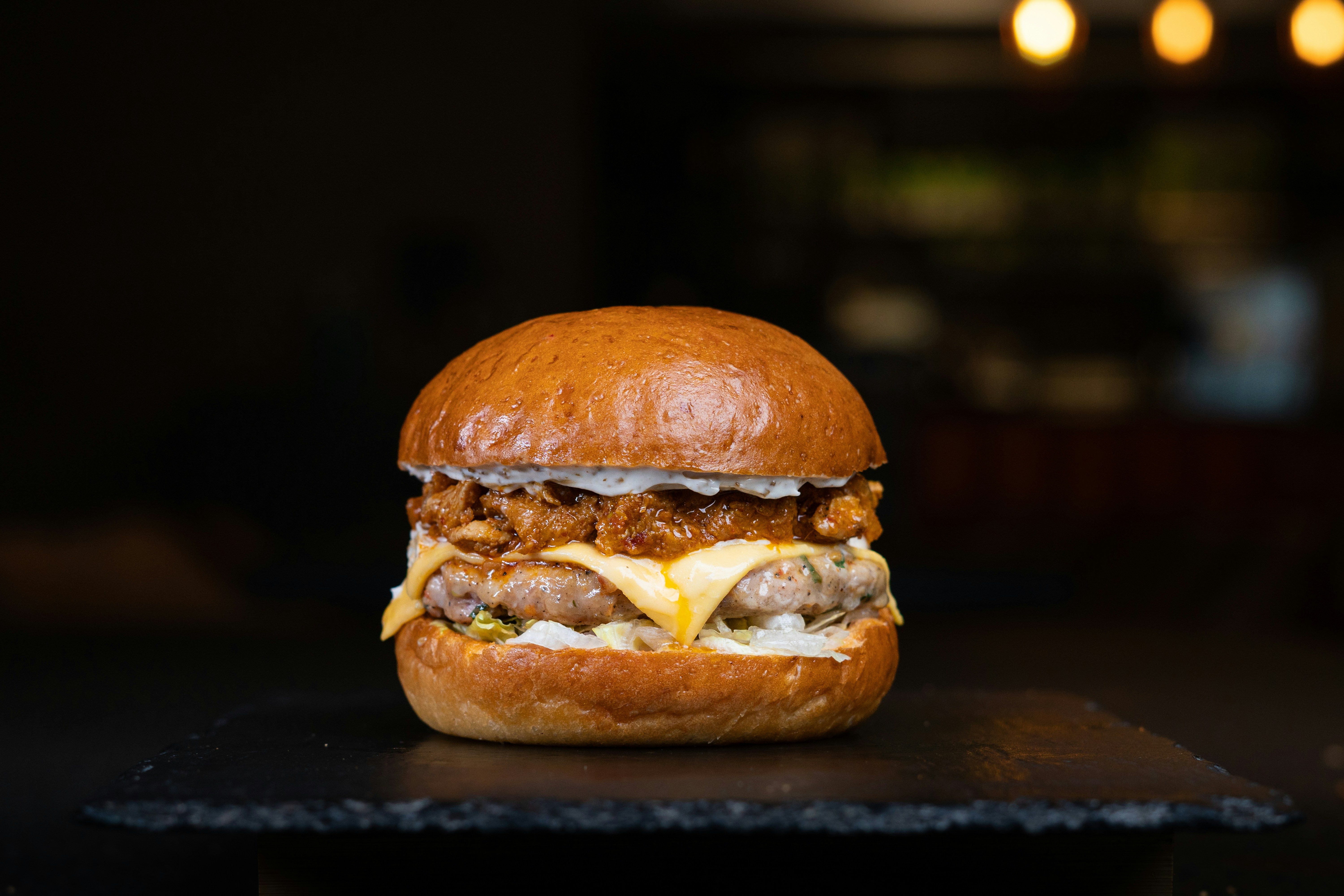 Hamburguesa doble con cheddar fundido sobre una tabla de pizarra